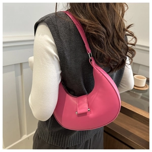 Detail of bright pink leather crescent underarm bag with silver metallic hardware detail