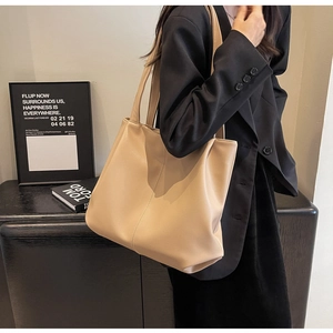Détail d'un grand sac cabas beige avec texture de cuir grainé porté sur l'épaule