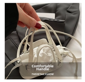 Detail of white lychee grain leather handbag with drawstring closure and metal hardware