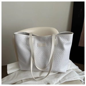Detail of white tote bag featuring woven diamond texture and FANYISSA BAGS logo