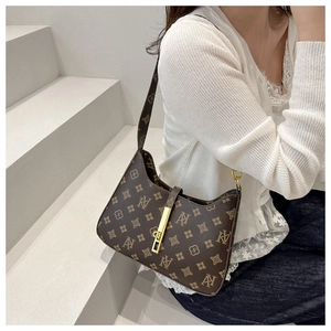 Detail of dark brown shoulder bag with vintage monogram and gold rectangular metal buckle