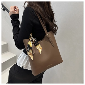 Dettaglio borsa tote marrone in ecopelle con foulard stampato e tracolla regolabile