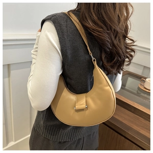 Detail of khaki crescent shoulder bag with leather texture and silver buckle accents