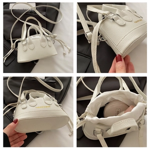 Detail view of white lychee pattern leather mini bag with drawstring and gold logo