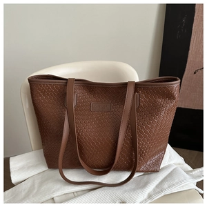 Macro shot of brown woven tote bag texture with embossed leather brand tag on office chair
