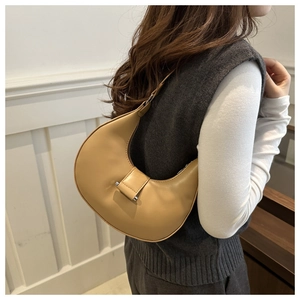 Close-up of khaki leather crescent shoulder bag featuring a silver metal buckle closure