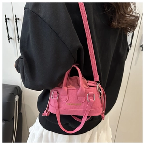 Close-up of pink mini PU leather crossbody bag with drawstring and gold FASHION logo