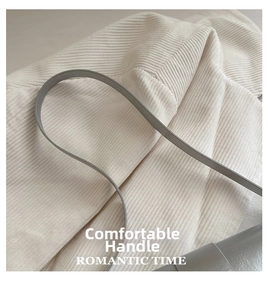 Gros plan sur la poignée en cuir gris d'un sac à bandoulière vintage au style rétro