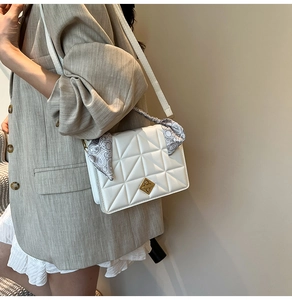 Détail du sac bandoulière matelassé blanc avec foulard en soie et fermoir doré