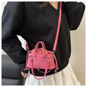 Detail of pink lychee leather handbag with drawstring liner and fashion logo