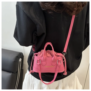 Detailed back view of a pink pebbled leather mini crossbody bag with drawstring liner