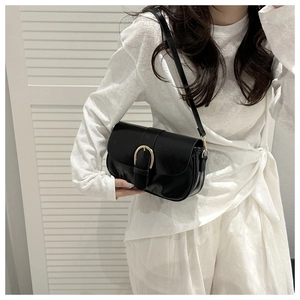 Détail du sac sous l'aisselle en cuir mat vintage avec boucle demi-cercle dorée élégante
