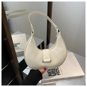 Detailed view of white crescent bag with silver metallic hardware and decorative buckle