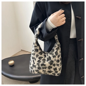 Détail d'un sac à main doux en fausse fourrure léopard avec texture peluche noire et blanche