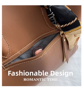 Detail of brown leather tote bag featuring contrast stitching and decorative silk scarf