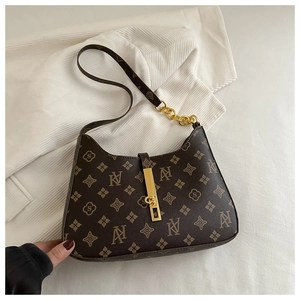 Detailed macro view of the coffee monogram leather surface and golden lock on the bag