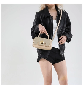 Détail d'un sac bandoulière bicolore beige et kaki avec rabat tressé et boucle dorée