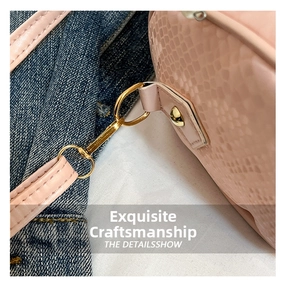 Close-up of pink snake-pattern leather handbag showing gold hardware and stitching