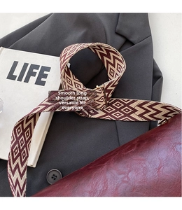 Nahaufnahme des verstellbaren geometrischen Jacquard-Schultergurts an burgunderroter Tasche