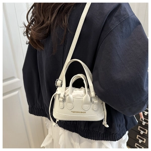 Close-up of a white mini crossbody bag featuring litchi texture and a gold logo