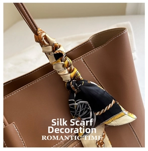Detail of a brown leather tote bag with elegant equestrian print silk scarf on handle