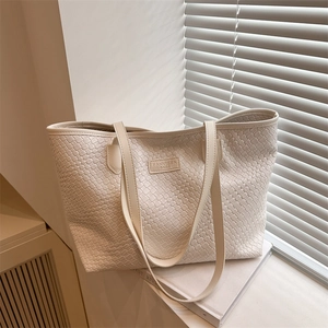 Chic beige woven texture tote bag with slim shoulder straps and minimalist logo