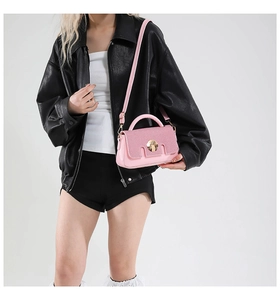 Detail of pink PU leather handbag with sequin flap and golden round buckle clasp