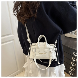 Close-up of white pebble leather crossbody bucket bag with drawstring and gold logo detail