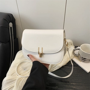 Minimalist beige PU leather shoulder bag with gold metal buckle shown in lifestyle setting