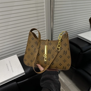 Brown monogram underarm bag with gold chain and buckle on minimalist background