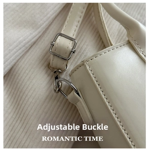 Detail of adjustable white leather shoulder strap with silver metal buckle and spring hook