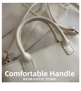 Détail du sac en cuir blanc crème avec coutures renforcées et poignée arrondie