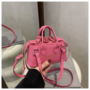 Detail of pink mini handbag showing lychee leather texture and drawstring closure