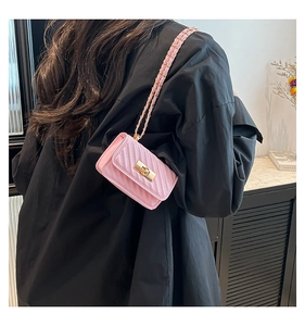 Detail of pink quilted crossbody bag with golden turn-lock and elegant chain strap