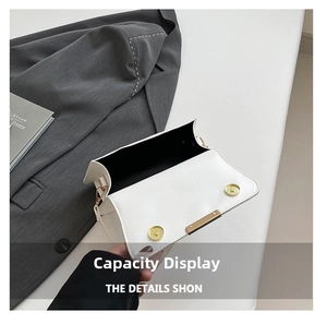 Detail view of white leather shoulder bag showing interior capacity and double magnetic snaps