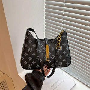 Black monogram underarm bag with gold metal clasp and chain strap in hand