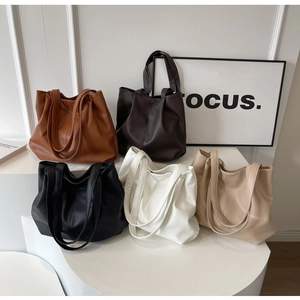 Détail de grands sacs fourre-tout en similicuir mat déclinés en cinq coloris chic