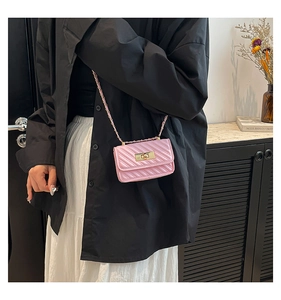 Close-up of bright pink quilted mini bag with golden metal twist lock and chain strap