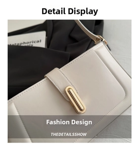 Detailed close-up of cream leather shoulder bag featuring a sleek gold metal buckle
