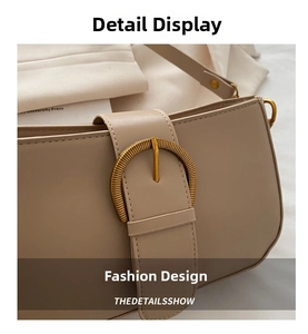 Gros plan sur le sac en cuir beige avec boucle dorée en D et texture élégante