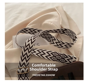 Detail of adjustable geometric patterned woven strap with gold metal hardware