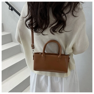 Close-up of brown faux leather mini tote bag with FASHION logo and detachable strap
