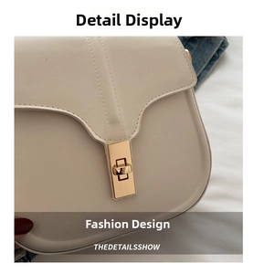 Close-up of cream saddle bag with wave-curve flap and minimalist gold rectangular metal lock
