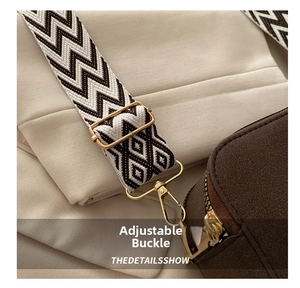 Detail of adjustable woven wide shoulder strap with gold buckle on a stylish camera bag