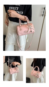 Pink snakeskin boston bag with pearl bow charm and crossbody strap detail