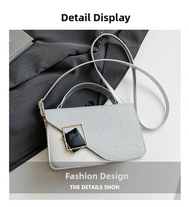 Detail of silver textured leather crossbody bag featuring a golden square buckle accent