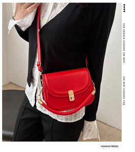 Model wearing red leather flap bag with gold hardware and dual straps for a trendy look