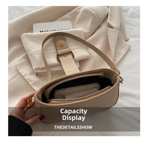 Vue intérieure du sac en cuir crème montrant les compartiments spacieux et la fermeture