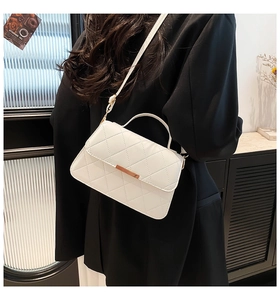 Gros plan sur le sac matelassé blanc avec barre dorée et détails de poignée élégants