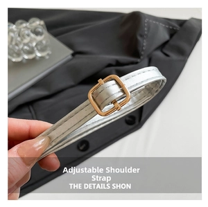 Detail of adjustable silver metallic leather strap with gold rectangular buckle on handbag